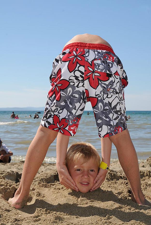 headless boy on beach